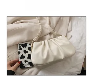 Detailed comparison showing light beige ruched hobo bag next to a cow print phone case