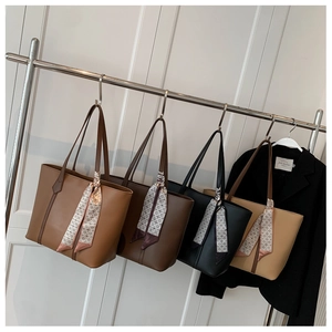 Détail de quatre sacs fourre-tout colorés avec des foulards géométriques sur les anses