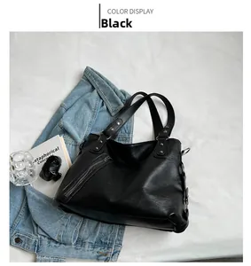 Detail view of black matte tote bag with decorative slanted zipper and metal rivets