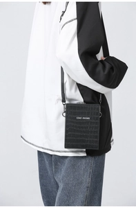 Detail view of black crocodile pattern mini shoulder bag with CONE KNOWS logo print
