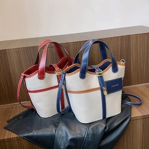 Detail of red and blue canvas bucket bags with faux leather trim and fashion charms