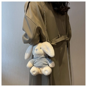 Gros plan du sac lapin en peluche avec un sweat à capuche gris et une chaîne dorée