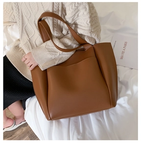 Detail of soft brown PU leather tote bag showing fine texture and sleek shoulder strap