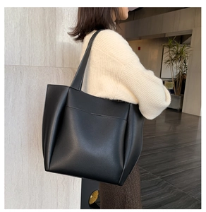 Detail of a black large-capacity PU leather tote bag with side pleats and front pocket