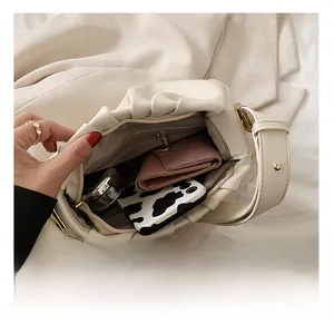 Detail view showing spacious interior with zipper pocket and white pleated cloud bag design