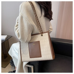 Détail du sac fourre-tout en toile avec garniture en cuir brun et chaîne en métal
