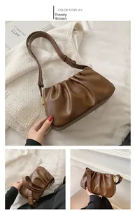 Detail view of the brown ruched hobo bag featuring a gold metal buckle and faux leather texture