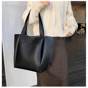Close-up of black soft PU leather tote bag with functional front pocket and long straps