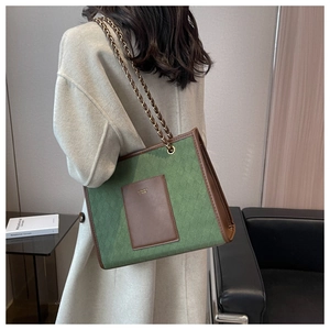 Détail du sac fourre-tout matelassé vert avec poche en cuir brun et chaîne dorée