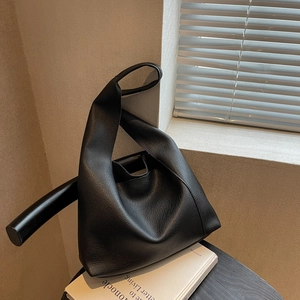 Sac fourre-tout minimaliste en cuir grainé noir au design géométrique sur un tabouret