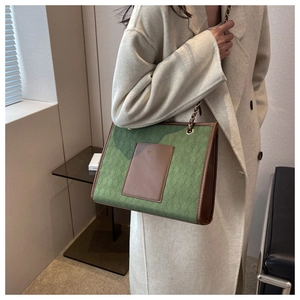 Détail du cabas vintage en daim matelassé vert avec bordures en cuir marron et chaîne