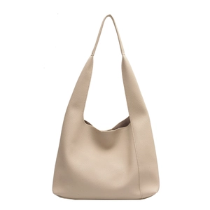Sac fourre-tout beige minimaliste en cuir grainé avec longue bandoulière sur fond blanc
