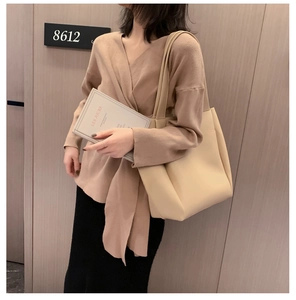 Detail of soft cream PU tote bag with shoulder straps shown on a model for commute style