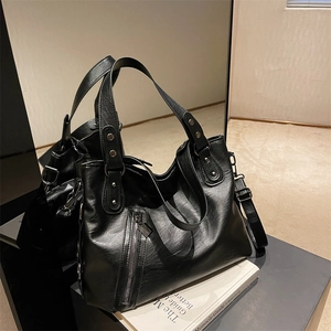 Minimalist black faux leather tote bag with silver studs and adjustable shoulder strap