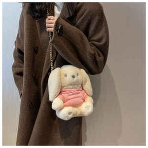Détail du sac lapin en peluche avec sweat rose et chaîne dorée sur un manteau en laine
