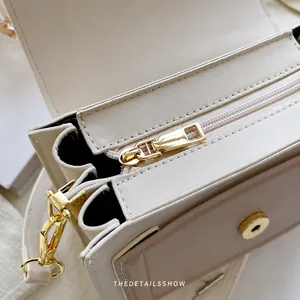 Detail showing smooth light gold zipper and premium faux leather texture of the crossbody bag