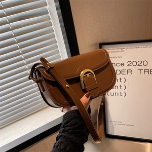 Classic brown leather saddle bag with gold horsebit buckle and adjustable strap