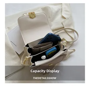 Interior storage capacity of the beige faux leather crossbody bag with items inside