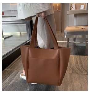 Detailed view of caramel PU leather tote bag with front pocket and fine stitching