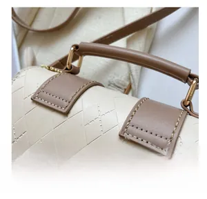 Macro detail of high-quality double stitching and luxury quilted texture on a beige handbag