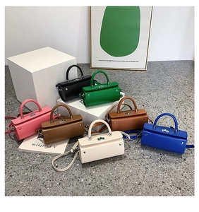 Detailed close-up of colorful leather cylinder handbags with silver twist locks and straps