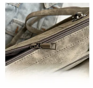 Close-up of the smooth metal zipper and matte texture of the gray commuter tote bag