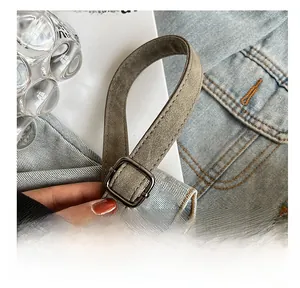 Detail of adjustable gunmetal buckle on grey frosted faux leather shoulder strap