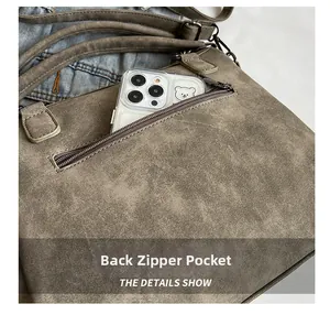 Detail of the back zipper pocket on a matte tote bag showing functional smartphone storage