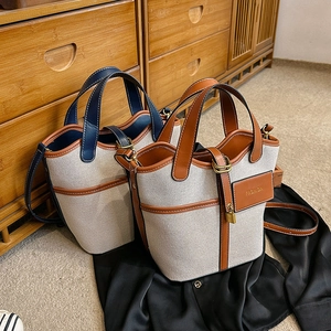 Canvas bucket bag with leather trim, including top handle and adjustable shoulder strap