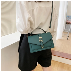 Rear view of a model wearing a dark green square leather crossbody bag with gold buckle