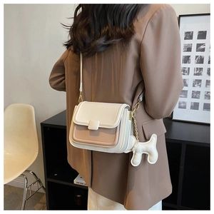 Crossbody square bag in beige and brown leather featuring a cute white dog charm