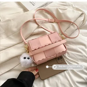 Pink woven mini crossbody bag size comparison with smartphone and cute plush charm