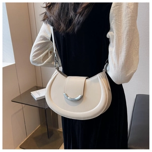 Vue arrière du modèle portant un sac selle beige avec boucle argentée et fine bandoulière