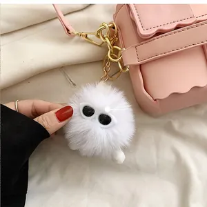 Close-up of white plush charm with sunglasses on a pink wavy edge crossbody bag