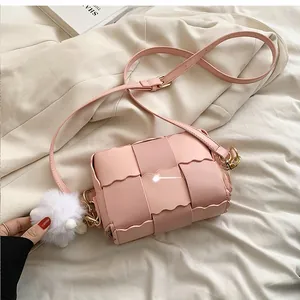 Detailed back view of a pink woven crossbody bag featuring unique scalloped wavy edges