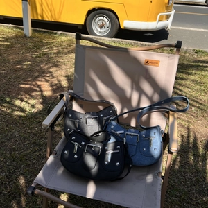 Chic punk-style crescent shoulder bags with silver studs and buckles on a folding chair
