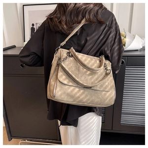 Macro detail of khaki matte tote bag with quilted square texture and metal chain handles