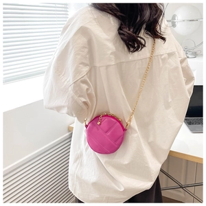 Détail du mini sac rond matelassé rose avec bandoulière chaîne dorée sur chemise
