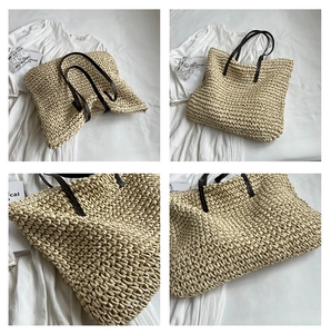 Detail of beige straw tote bag with brown leather handles and handcrafted woven texture