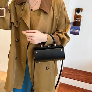 Chic black cylinder handbag with silver buckle and crossbody strap for modern women
