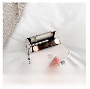 Interior view of small white flap bag showing space for lipstick and notepad