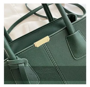 Close-up of golden metal hardware on dark green lychee pattern leather handbag