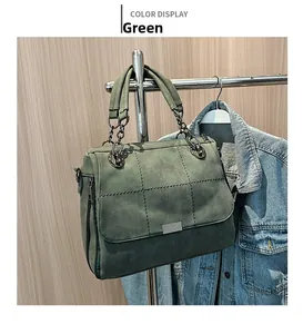 Detail of green suede tote bag featuring square quilted stitching and chain handle