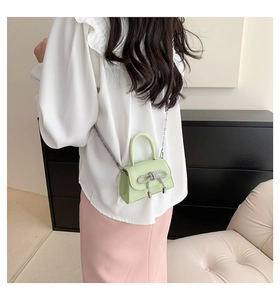 Detailed back view of a mini light green crossbody bag with silver bow detail and chain