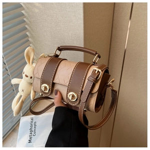 Detail of khaki quilted cylinder bag with gold twist lock and cute bunny charm