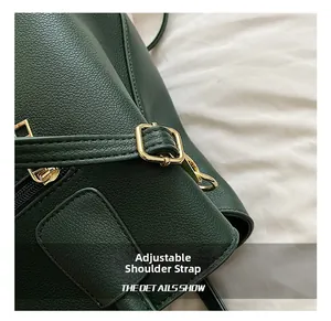 Detail of dark green lychee leather handbag showing golden buckle and fine stitching
