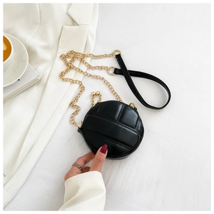 Détail du mini sac bandoulière rond noir avec cuir matelassé et chaîne dorée