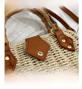 Close-up of natural bamboo handle and woven fiber texture on a stylish straw handbag