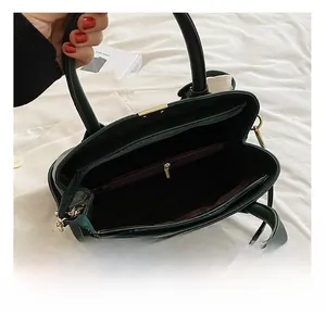 Deep green leather tote interior showing main compartment and burgundy lining