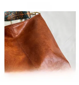 Close-up of caramel brown pebble leather bag with bohemian geometric patterned strap